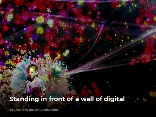 Standing in front of a wall of digital flowers.