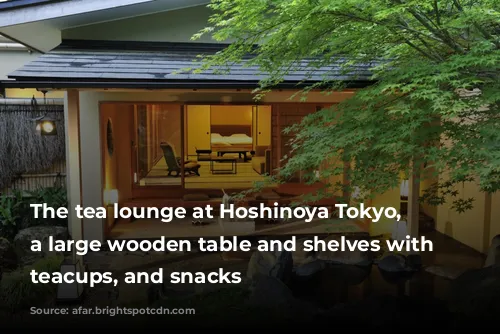 The tea lounge at Hoshinoya Tokyo, with a large wooden table and shelves with teapots, teacups, and snacks