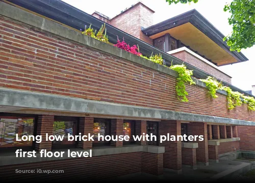 Long low brick house with planters at first floor level