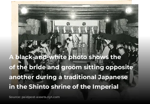 A black-and-white photo shows the families of the bride and groom sitting opposite one another during a traditional Japanese wedding in the Shinto shrine of the Imperial hotel 
