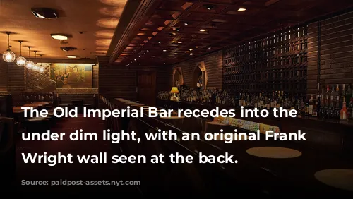 The Old Imperial Bar recedes into the distance under dim light, with an original Frank Lloyd Wright wall seen at the back. 
