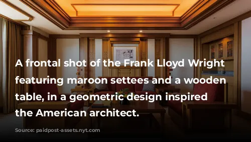 A frontal shot of the Frank Lloyd Wright suite featuring maroon settees and a wooden coffee table, in a geometric design inspired by the American architect.
