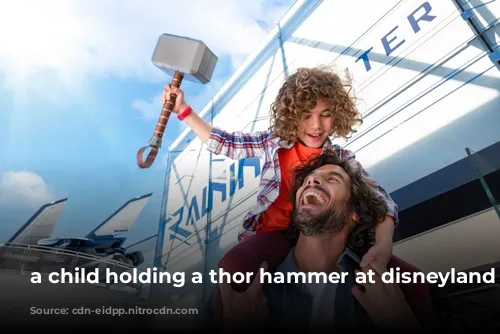 a child holding a thor hammer at disneyland paris