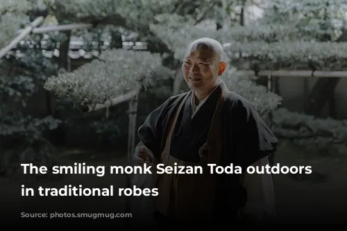 The smiling monk Seizan Toda outdoors stands in traditional robes