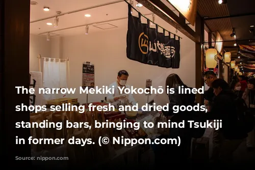 The narrow Mekiki Yokochō is lined with shops selling fresh and dried goods, alongside standing bars, bringing to mind Tsukiji Market in former days. (© Nippon.com)