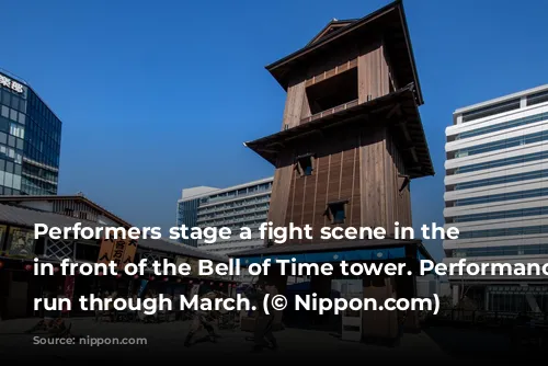 Performers stage a fight scene in the square in front of the Bell of Time tower. Performances will run through March. (© Nippon.com)