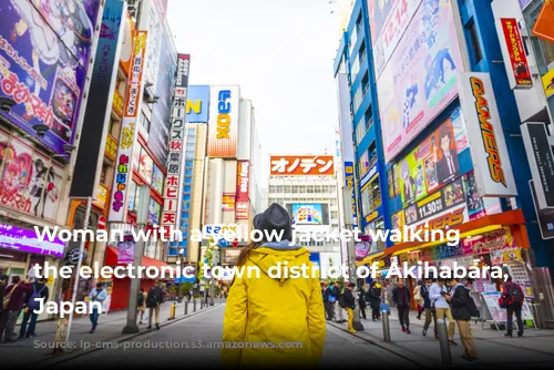 Woman with a yellow jacket walking in the electronic town district of Akihabara, Tokyo, Japan