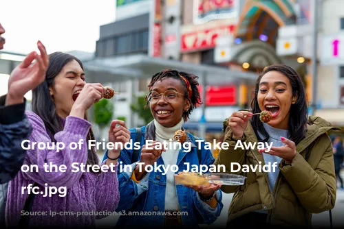 Group of Friends Eating Take Away Food on the Street in Tokyo Japan Davidf GettyImages-1166370053 rfc.jpg