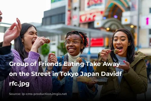 Group of Friends Eating Take Away Food on the Street in Tokyo Japan Davidf GettyImages-1166370053 rfc.jpg