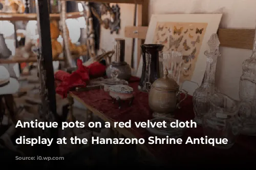 Antique pots on a red velvet cloth on display at the Hanazono Shrine Antique Market.