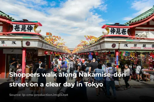 Shoppers walk along Nakamise-dōri shopping street on a clear day in Tokyo