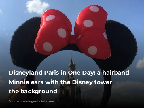 Disneyland Paris in One Day: a hairband with Minnie ears with the Disney tower on the background