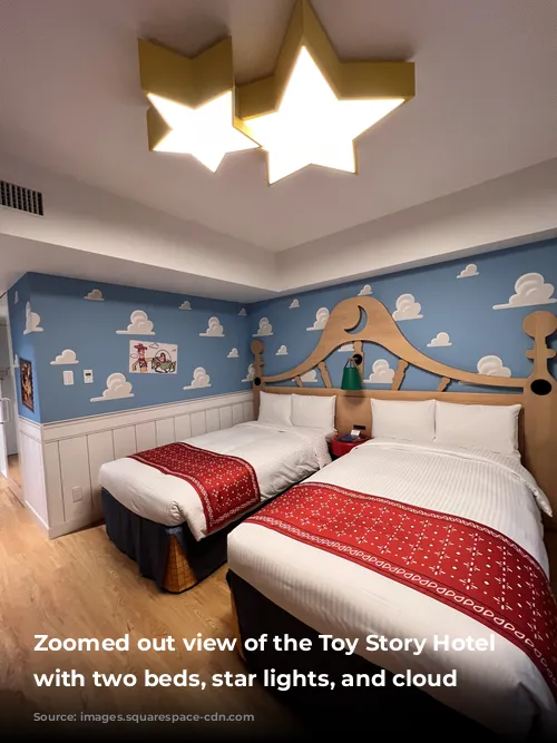  Zoomed out view of the Toy Story Hotel bedroom with two beds, star lights, and cloud wallpaper 